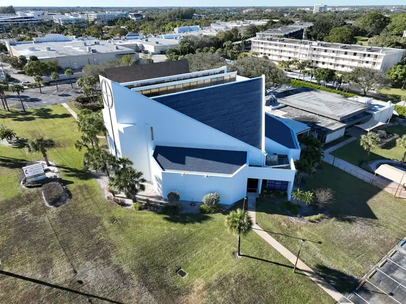 Modern white church building with a dark finished roof