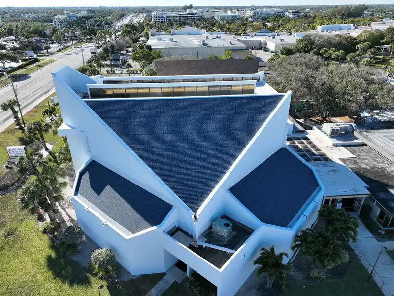 Aerial view of a white building with a geometric finished roof